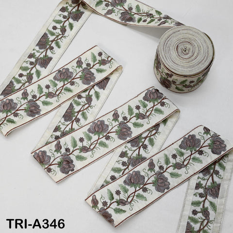 a collection of decorative fabric pieces with floral patterns, including a spool of thread and a spool of ribbon.