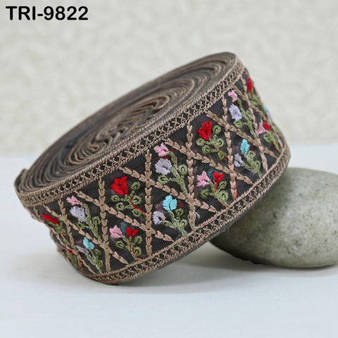 A decorative fabric border with floral patterns in various colors, including red, green, and blue, is displayed on a white surface.