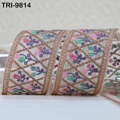 a decorative fabric with a floral pattern, featuring a repeating design of pink and purple flowers on a beige background.