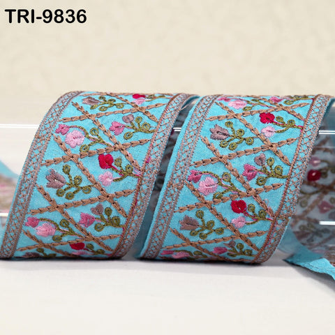 two rolls of embroidered fabric with a floral pattern in shades of blue and pink.