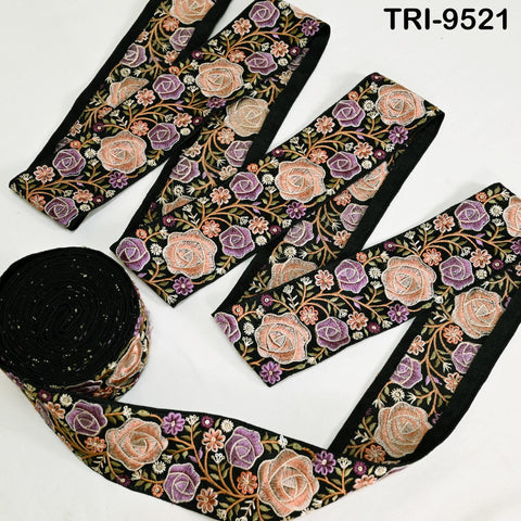 a collection of decorative fabric pieces with floral patterns in shades of pink, orange, and purple. The fabric appears to be black and has a floral motif. The pieces are arranged in a way that suggests they are part of a larger collection or set.