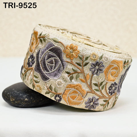 a decorative fabric with a floral pattern, including roses and other colorful flowers, and a beige background.