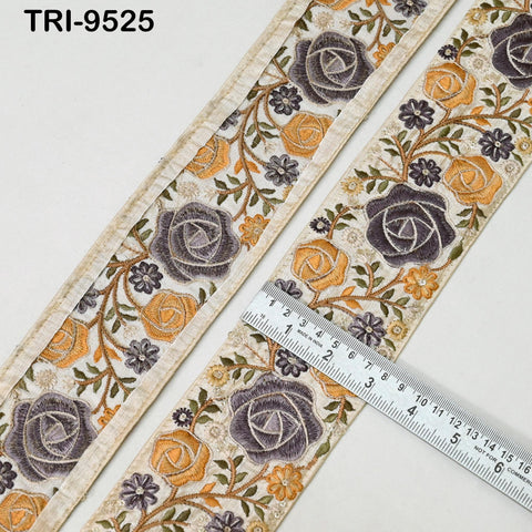 a close-up view of a decorative fabric with a floral pattern, featuring a ruler placed on top of it to measure its length.