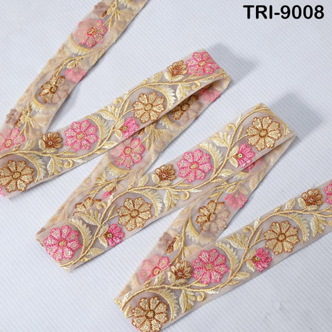 a decorative fabric with a floral pattern, featuring pink and gold flowers arranged in a repeating design. The fabric appears to be a decorative trim or lace, with a floral motif that adds a touch of elegance and sophistication to the design.
