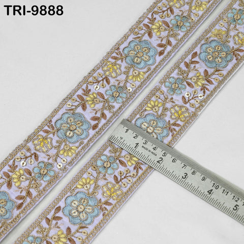 a decorative floral embroidery trim with a ruler placed on top of it, indicating the size of the trim.