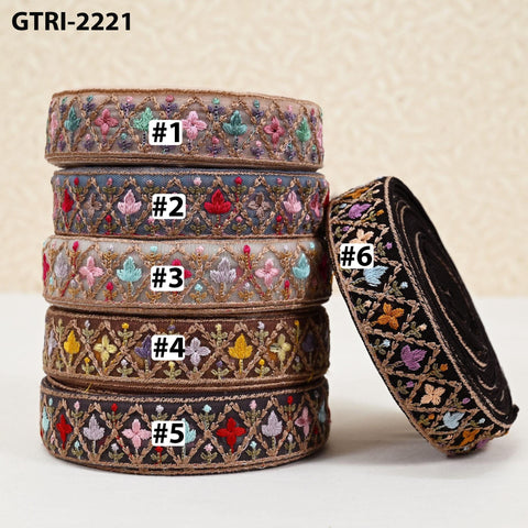 A stack of five ornate, embroidered fabric pieces with various floral and geometric patterns.