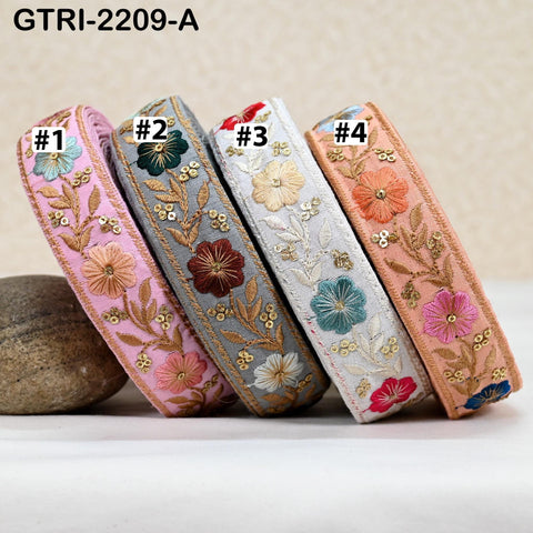 Four colorful embroidered fabric pieces, each with a unique floral pattern, arranged in a row.