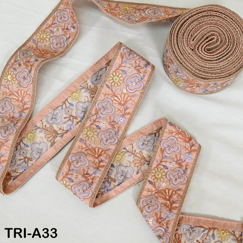 a collection of decorative fabric pieces, including a pink and blue floral patterned ribbon and a round, coiled ribbon.