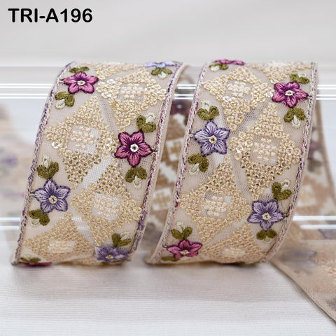 two decorative fabric pieces with a floral pattern, featuring a combination of pink, purple, and green flowers. The pieces appear to be made of a light-colored material, possibly lace or a similar fabric.