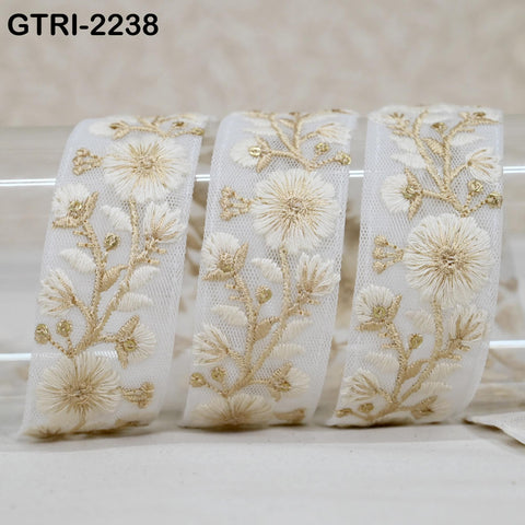 three white fabric pieces with intricate gold floral embroidery designs.