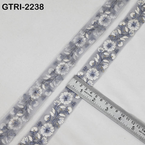 a piece of fabric with a floral embroidered design, and a ruler is placed on top of it, indicating the size of the fabric.