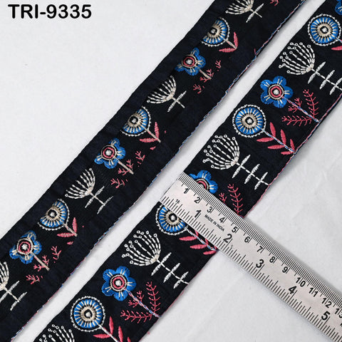 a close-up view of a decorative fabric with a floral pattern, featuring a ruler for scale.
