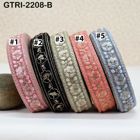 A collection of five decorative fabric ribbons in various colors, including pink, black, peach, blue, and gray, arranged in a row.