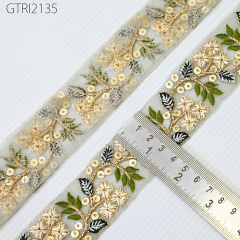 a close-up view of a decorative fabric with a floral pattern, featuring a ruler for scale.