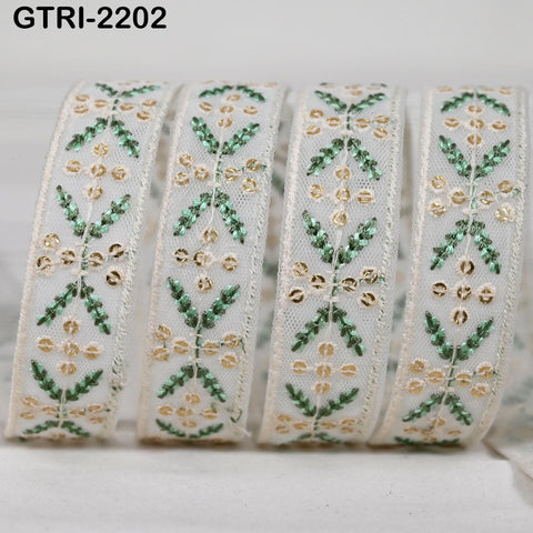 A close-up image of a decorative ribbon with a floral pattern in shades of green and gold.