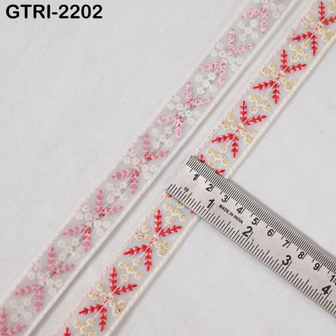 two spools of ribbon with a floral pattern, and a ruler is placed on top of the ribbon to measure its length.