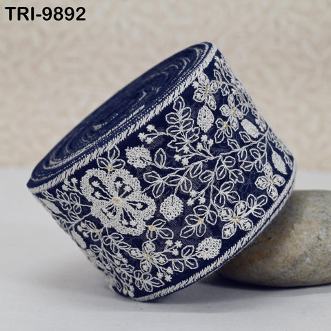 A close-up image of a decorative blue and white fabric with intricate floral patterns, resting on a surface.