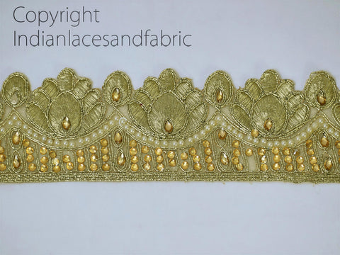 a decorative gold-colored embroidered border with intricate designs and small golden beads or pearls.