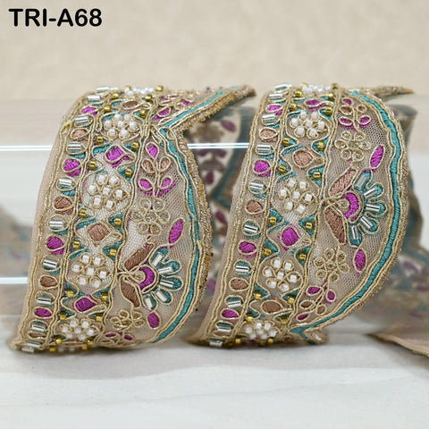 two decorative fabric pieces with intricate floral and bead patterns, placed on a white surface.