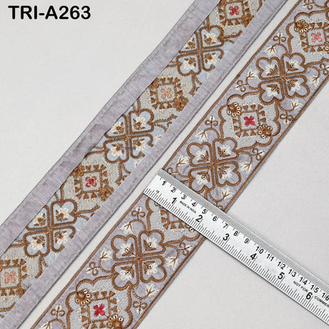 a decorative border with a floral pattern and a ruler placed next to it, indicating the size of the border.