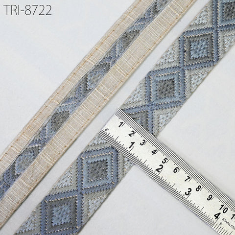 a close-up view of a decorative fabric with a diamond pattern, placed on a white surface. A ruler is placed next to the fabric, indicating the size or dimensions of the fabric.