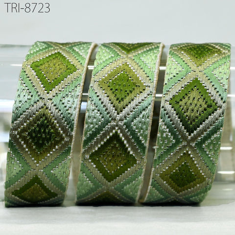 three green and beige patterned fabric rolls arranged in a row, with a white background.