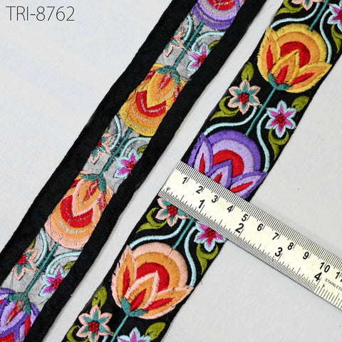 a close-up view of a decorative fabric with a floral pattern, featuring a ruler for scale.