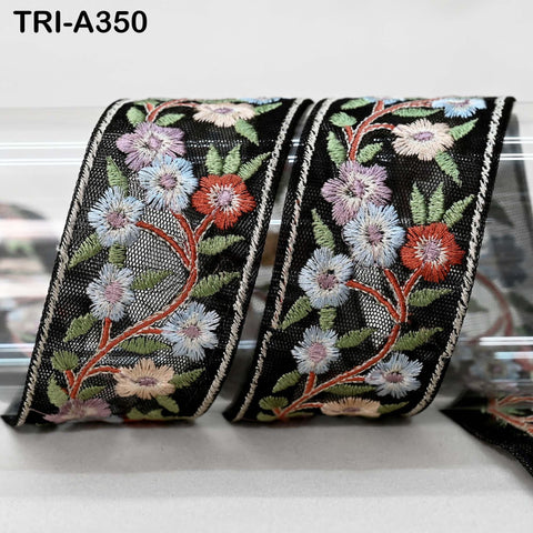 two decorative fabric pieces with a floral pattern. The fabric pieces are black and have a floral design with red, white, and blue flowers. The image does not contain any text or additional objects.