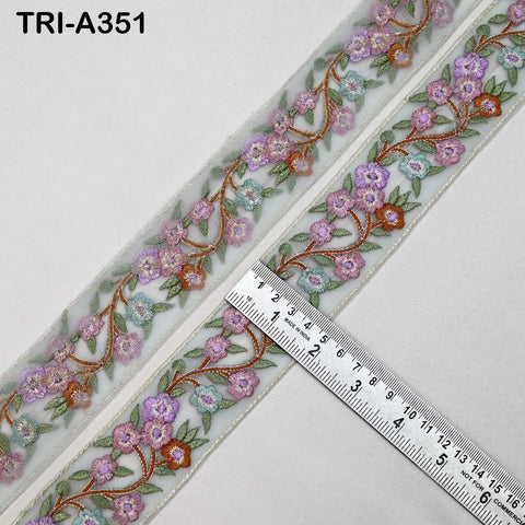 a decorative fabric with a floral pattern, featuring a ruler placed on top of it to measure the length.