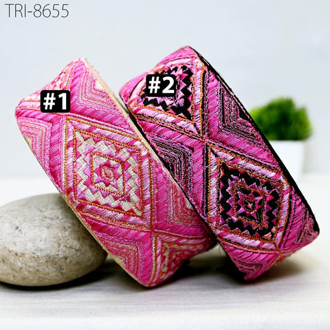 two pink and black patterned headbands, each with a unique design, placed on a white surface.