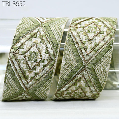 two pieces of green and white embroidered fabric, with intricate geometric patterns and designs.