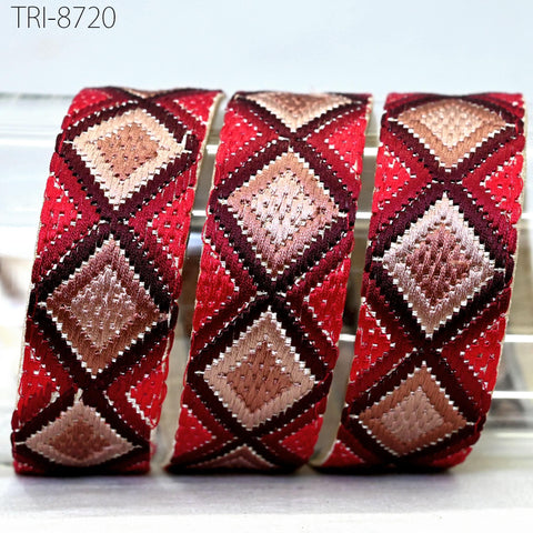 three colorful, diamond-shaped fabric pieces with a red and brown pattern, arranged in a row.
