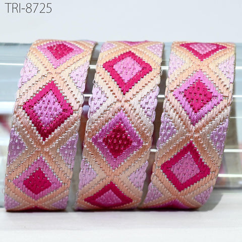 three colorful, diamond-shaped fabric pieces with a repeating pattern of pink and orange diamonds. The pieces are arranged in a row, with the middle piece being the largest and the other two being smaller in size.