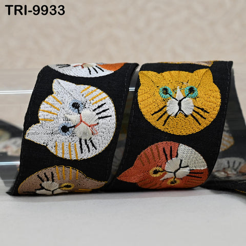a pair of cat-themed fabric items, including a black and white cat and a yellow and orange cat, both with intricate embroidered designs.