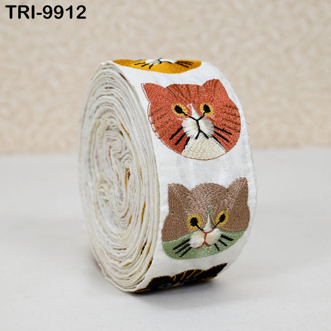 A white fabric with colorful cat embroidered patterns on it.