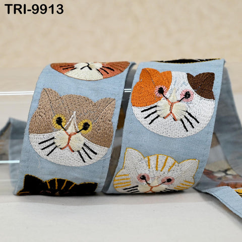 a pair of blue fabric items with embroidered cat faces on them.