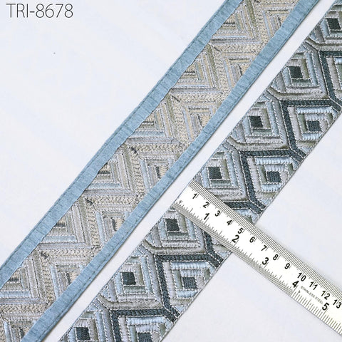 a close-up view of a decorative fabric with a geometric pattern, placed on a white surface. A ruler is placed next to the fabric, indicating its size or dimensions.