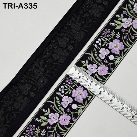 a close-up view of a decorative fabric with a floral pattern in shades of black and purple. A ruler is placed on the fabric, indicating its size.