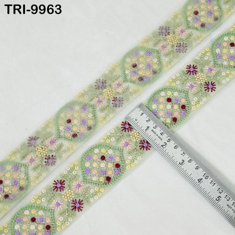 a decorative fabric with a floral pattern, featuring a ruler placed on top of it to measure its length.