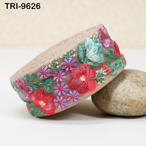 a decorative fabric with a floral pattern, including red, purple, and green flowers, and a beige background.