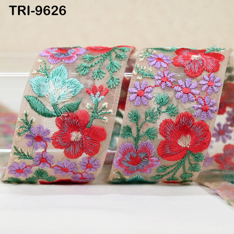 two pieces of fabric with intricate floral embroidery in shades of red, green, and purple.
