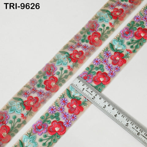 a decorative fabric with a floral pattern, featuring red and green flowers, along with other colorful floral designs. A ruler is placed next to the fabric, indicating the size of the fabric.
