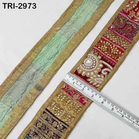 gold patchwork embroidered trim strip combining red, maroon, and gold panels with sequins and beadwork. A ruler placed across the trim shows its width to be around 3 inches.